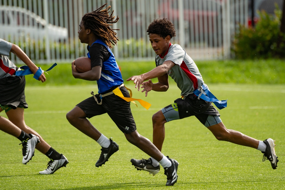 students at tuition-free PBMA playing flag football on an outdoor field