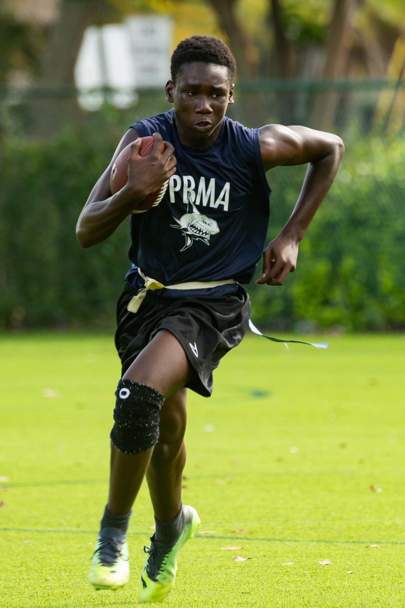 student athlete at PBMA charter school running with a football